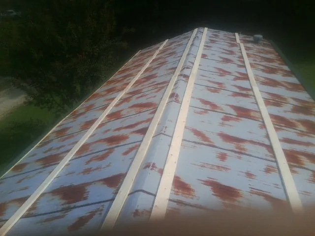 Rusted metal roof panels with new wood purlins before replacement — Storm Damage Roof Repair in Inman by Roofing Brothers